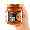 Jar of Red Thai Curry Paste held in a hand with a white background